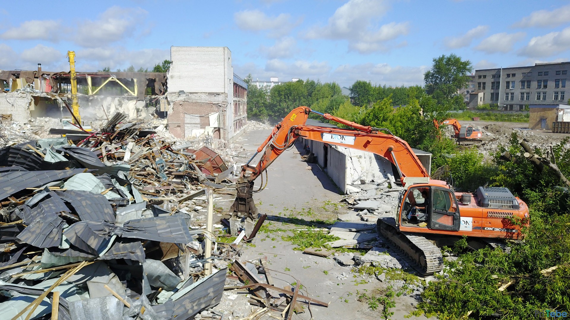Демонтаж зданий экскаватором разрушителем.
